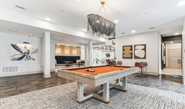 a room with a pool table and chairs